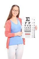 Young girl pointing on eyesight test with a stick photo