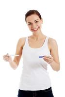 Happy beautiful young woman with pregnancy test. photo