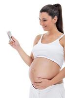 Pregnant woman looking at baby scan photo