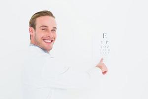 Smiling optician pointing eye test
