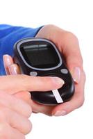 Closeup of finger with blood and glucose meter photo