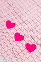 Corazones de papel en el gráfico de electrocardiograma, medicina y concepto de salud foto
