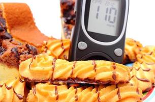 Fresh baked pastry and glucose meter. White background