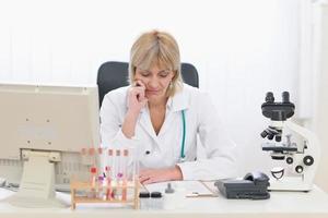 médico de mediana edad concentrado mujer que trabaja en la oficina foto