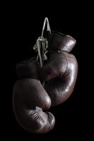 old Boxing Gloves, hanging, isolated on black Background photo
