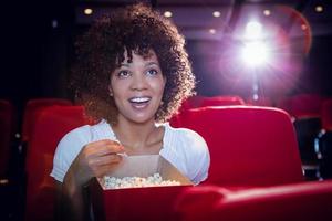 Smiling young woman watching a film photo
