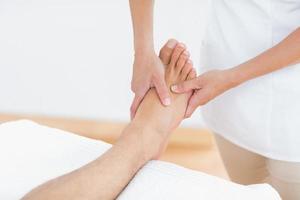 fisioterapeuta haciendo masaje de pies foto