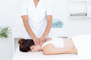 fisioterapeuta haciendo masaje de cuello foto