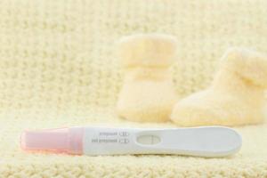 A pink and white pregnancy test displaying a negative result