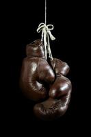 old Boxing Gloves, hanging, isolated on black Background photo