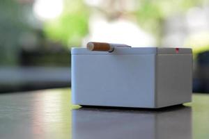 White Ashtray and cigarette on the table photo