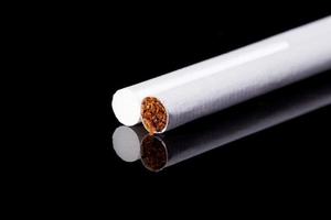 two thin cigarettes isolated on black background macro
