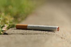 Cigarette on asphalt photo