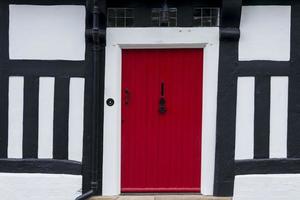 Red front door in a timber framed Tudor house photo