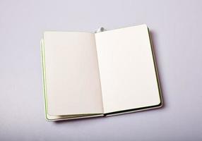Open notepad with blank pages on white table