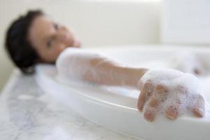 mujer joven en baño de burbujas, retrato foto