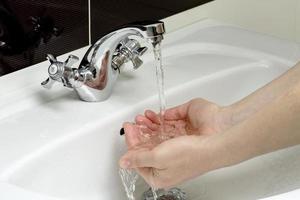 la persona se lava las manos en el baño