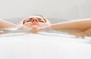 stressed young woman laying in bathtub