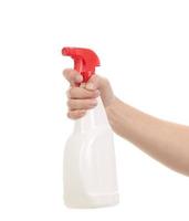 Mano sosteniendo la botella de spray de plástico blanco. foto