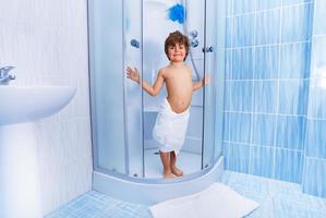 Happy little boy in the hotel shower photo
