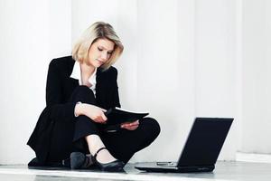 mujer de negocios joven usando laptop en la acera foto