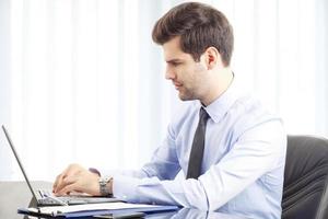 Portrait of young businessman with laptop photo
