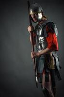 Soldado romano en armadura con una lanza en la mano foto