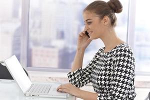 Young businesswoman with laptop and mobile