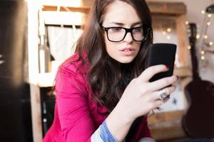 Young beautiful hipster woman using smart phone at office photo