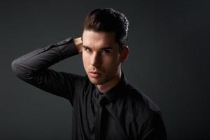 Portrait of a stylish young man with hand in hair photo