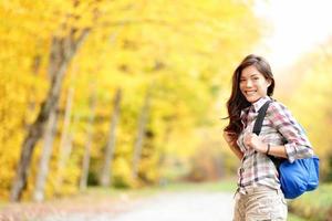 Fall hiking girl in autumn forest photo