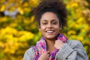 atractiva joven afroamericana sonriendo en otoño foto