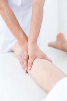 fisioterapeuta haciendo masaje de piernas foto
