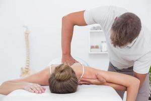 fisioterapeuta haciendo masaje de espalda a su paciente