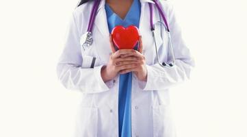 Doctor con estetoscopio sosteniendo corazón, aislado sobre fondo blanco.