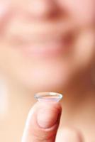 Womans finger with contact lens
