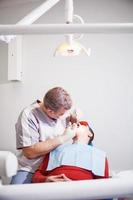 Dentist makes dental treatment to the patient.