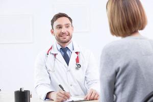 cardiólogo sonriente hablando con el paciente foto