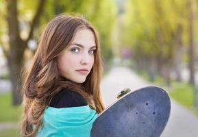 Teenage girl with skateboard photo
