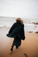 Girl walking on the sea shore photo