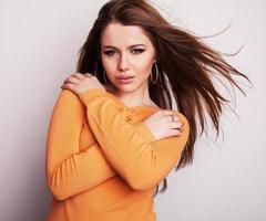 Young beauty model girl iin casual orange sweater. photo