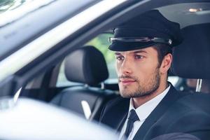 Male chauffeur sitting in a car photo