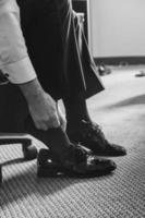 male hand putting on formal shoes