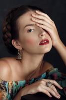 Retrato de una hermosa joven con joyas hechas a mano posando foto
