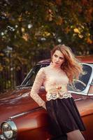 stylish woman standing with a retro car in fashion dress photo