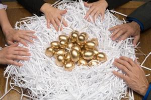 Colleagues around a nest of gold eggs
