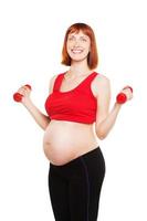 Beautiful pregnant woman doing exercise with dumbbells. Healthcare. Isolated over photo