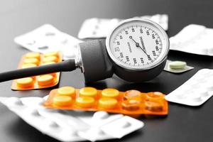 medidor de presión arterial y pastillas sobre la mesa