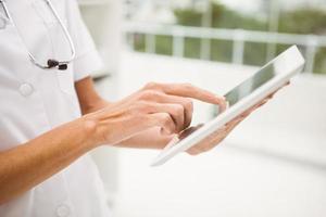 Primer plano del médico con tableta digital en consultorio médico foto