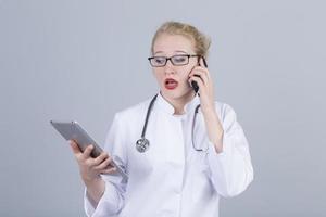 joven doctora sosteniendo tableta, malas noticias en el teléfono foto